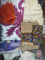 Overall view of unfinished needlepoint canvases spread out