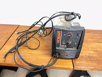 Front view of Hobart Handler 140 welder with attached cables