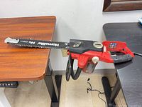 Full view of Homelite chainsaw on table, shows overall condition and cord
