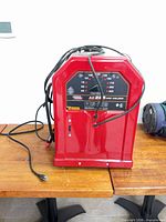Front view of red Lincoln Electric AC-225 welder with power cord and leads visible
