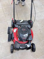 Top view of red and black Powersmart mower showing engine housing marked 170cc, wheels, handle, and side discharge chute