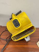 Full view of yellow Rite-Hite air mover showing housing, grille and power cord