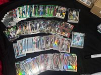 Wide view of laid-out football cards showing quantity, loaders, sleeves, mix of Panini products