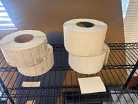 Four rolls of die-cut thermal label paper on shelf
