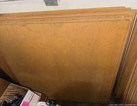 Stack of unfinished particleboard panels standing upright
