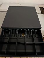 Drawer open revealing bill clips and coin sections, key visible