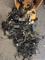 Pile of tangled power adapters on floor