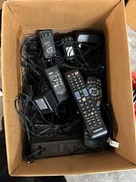 Overview of box with remotes, adapters, cables