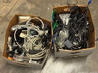 Two boxes filled with mixed cables showing variety of types and colors