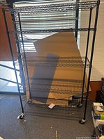Front view of entire shelving unit showing five shelves and casters
