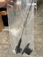 Single antenna in sleeve showing whip, coil, plastic base, adhesive pad