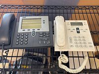 Wide shot of two Cisco IP phones on shelf showing overall lot contents