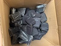 Open carton filled with numerous black Clickfree zip cases, some still in individual plastic bags.