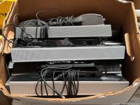 Box containing multiple Dell AS501 monitor soundbars with attached cables