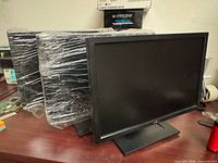 Front view of three Dell E1910c monitors, two wrapped in plastic, one unwrapped on stand.