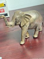 Left side view of brass elephant showing etched patterns and patina