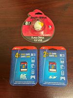 Front view of sealed EMTEC 8GB USB flash drive and two Nexxtech SD card packages