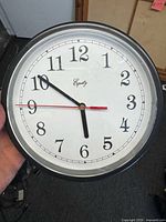 Front view of Equity wall clock showing dial, hands, and case