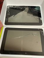 Front view of two Hannspree tablets showing shattered screens