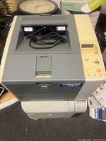 Two stacked HP LaserJet printers with power cable visible