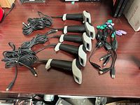 Four of the five scanners with attached cords and adapters visible on tabletop
