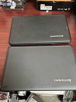 Two closed Lenovo laptops, primary item is G560