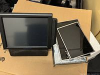 Front view of LivePOS touchscreen POS terminal alongside loose bare LCD panels