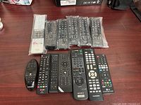 Top view showing 13 remotes arranged on table