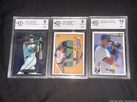Front view of three BCCG slabbed baseball cards showing grades 9, 9, 10