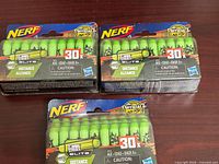 Three sealed packs of green Nerf Zombie Strike Elite 30-count darts
