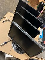 Four HP monitors stacked side-by-side with cables visible