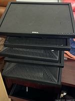 Stack of six Dell monitors showing front bezels and lack of bases