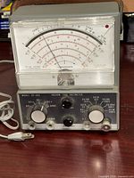 Front view of Micronta 22-025 vacuum tube voltmeter showing meter scale, control knobs and attached power cord