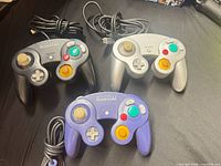 All three wired Nintendo GameCube controllers showing fronts and cables
