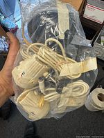Multiple wired security cameras bundled in plastic bag showing cords and housings