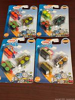 Four sealed blister cards of Thomas & Friends Minis displayed on table