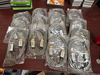 Fourteen individually packaged VIZIO braided HDMI cables on table