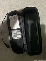 Power bank inside open carrying case with manual and cable visible