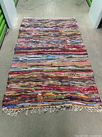 Full view of entire handwoven rag rug displaying size, stripe pattern and fringe