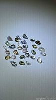 Full group of pear-cut multicolour tanzanites spread on surface