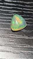Triangular crystal opal showing strong green and orange flashes