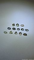 All twelve loose tanzanite gemstones arranged in rows