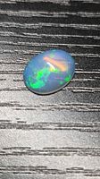Opal on textured surface showing play of colour