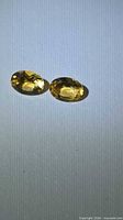 Pair of oval golden citrines on neutral background