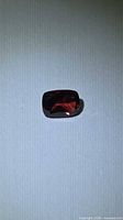 Front view of cushion-cut garnet showing color and shape