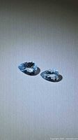Pair of pear-cut aquamarines on neutral background