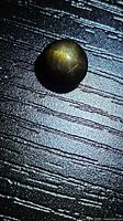 Oval cabochon sapphire on textured surface