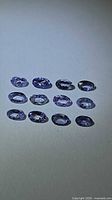 All 12 oval tanzanites grouped on neutral background