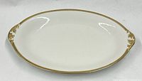 Full view of oval ivory porcelain tray with gold rim