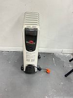 Front view of DeLonghi oil-filled radiator heater showing control panel, fins, casters and cord